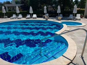 a swimming pool with blue water and chairs and umbrellas at Dream 3 in Sunny Beach