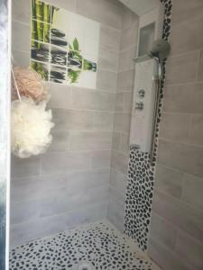 a shower with a black and white tiled shower at Emplacement de tente in Hardinghen