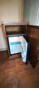 an empty refrigerator with its door open on the floor at Pensión Los Pasiegos in Reocín