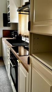 a kitchen with white cabinets and a stove top oven at Villa Katerinaki in Kos