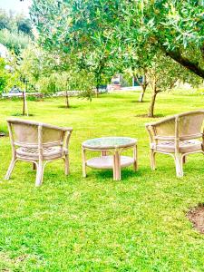 three park benches with a table in the grass at Villa Katerinaki in Kos