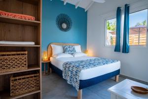a bedroom with a bed and a blue wall at Villa piscine privée Grand-Bourg proche plage in Grand-Bourg