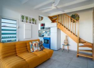 a living room with a couch and a staircase at Villa piscine privée Grand-Bourg proche plage in Grand-Bourg