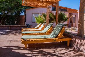 a group of chairs sitting on a patio at Hotel-Camping Takha Takha in San Pedro de Atacama