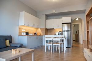 a kitchen and living room with a table and a couch at Easy Living Tinos in Vrachonisída Chántra