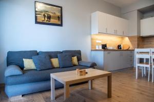 a living room with a blue couch and a table at Easy Living Tinos in Vrachonisída Chántra