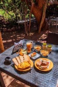 a table with plates of food and drinks on it at Hotel-Camping Takha Takha in San Pedro de Atacama