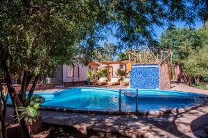 a swimming pool in a yard with a house at Hotel-Camping Takha Takha in San Pedro de Atacama