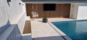 a patio with a swing and a swimming pool at Villa Maja in Sutomore