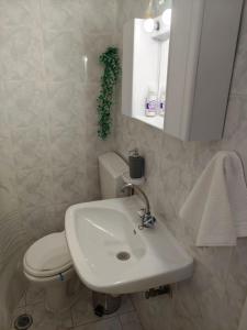 a bathroom with a white sink and a toilet at Mary's Home in Kalamata +26 photos