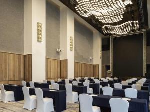a conference room with white chairs and a screen at Sofitel Haikou in Haikou +100 photos
