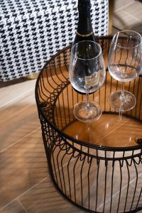 two wine glasses and a bottle on a table at Allenbeach TLV- Adults only - WE HAVE SHELTER in Tel Aviv