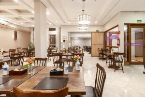 a restaurant with wooden tables and chairs in a room at Tri Hotel Executive Santa Maria in Santa Maria