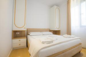 a bedroom with a bed with two towels on it at Hotel by Jon in Dhërmi