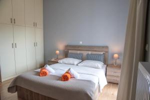 a bedroom with two beds with orange towels on them at Easy Living Tinos in Vrachonisída Chántra