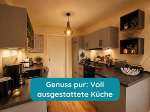 a kitchen with a counter top with the words genus put volyss pesticide at Meerglück am Beltblick Fehmarn - FeWo mit Sauna, Blick auf Ostsee und Leuchtturm, nur 150 m zum Meer in Fehmarn