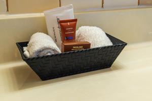 a black basket sitting on a bathroom counter with products at The Guv'nor Inn & Pub in St. John's +36 photos