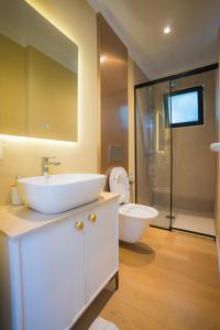 a bathroom with a sink and a toilet and a shower at Hotel by Jon in Dhërmi +22 photos
