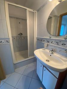 a white bathroom with a sink and a shower at Baltic Garden Stay in Kołobrzeg +40 photos