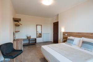 a bedroom with a large white bed and a chair at La Rocca di PA in Tropea