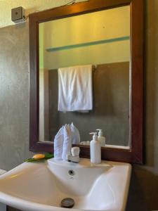 a bathroom sink with a mirror and a towel at Turtle Breeze Rekawa in Tangalle