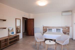 a bedroom with a bed and two chairs and a table at La Rocca di PA in Tropea