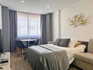a bedroom with a bed and a table and a couch at Timeless Beach V - Apartment in Armação de Pêra