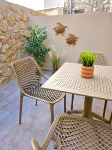 a table and chairs with plants on a patio at Anthouli Homes 1, steps from beach and centre in Kardamaina