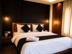 a bedroom with a large white bed with black walls at Satya Avenue Dehradun, Near Pearl Paradise IT park Road in Dehradun
