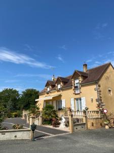 a large yellow house with a balcony on a street at Le Petitepinay Chambres et Gîte in Moitron-sur-Sarthe