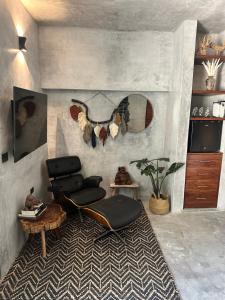 a living room with a chair and a table at Aldea Pukna Tulum in Akumal