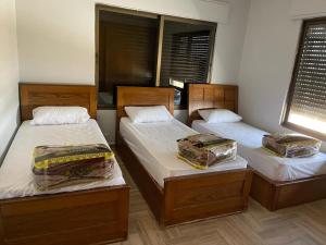 a room with two beds with trunks and a window at جبال جرش in Jerash