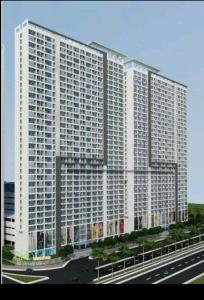 a large white building with a highway in front of it at Studio Pleasant Tifolia in Jakarta