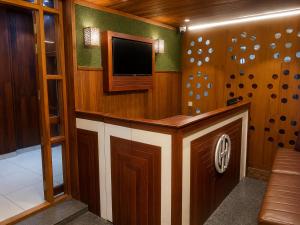 a room with a bar with a tv on the wall at Nova North Inn in Cochin