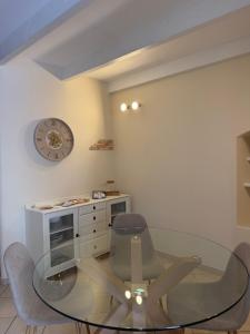 a dining room with a glass table and chairs at Casa Dani - terrazza relax, parcheggio gratuito e comfort a due passi da Oneglia in Imperia