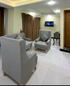 a living room with two chairs and a tv at Seven sky hotel in Murree