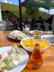 ein Tisch mit Tellern voller Essen und einer Flasche Soße in der Unterkunft Baba I Dede in Galičnik