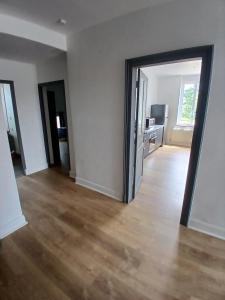 an empty room with a door open to a living room at 4-person apartment La Salamandre in Gondreville