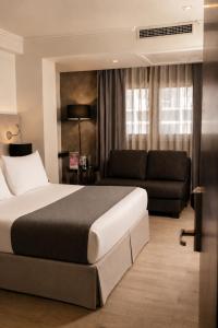 a bedroom with a large bed and a couch at Hotel Sommelier Agustinas in Santiago