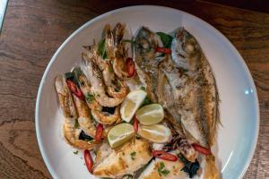 a plate of fish and shrimp on a table at Hotel by Jon in Dhërmi