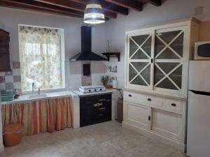 a kitchen with a stove and a sink and a window at Casa Rivendell in Ladrido