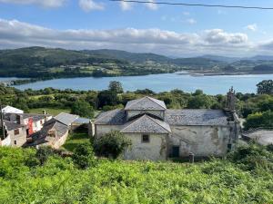 an old house on a hill next to a lake at Casa Rivendell in Ladrido