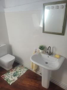 a bathroom with a white sink and a toilet at Casa Rivendell in Ladrido +8 photos