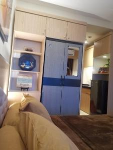 a room with a blue door and a kitchen at Studio Pleasant Tifolia in Jakarta