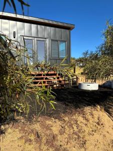 a small house with a lot of plants in front of it at Quiet Luxury Tiny Home Retreat Rustic Chic in Aguanga