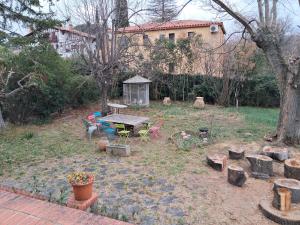 a backyard with a table and chairs and a tree at maison d'hôte et espace de repos in Prades