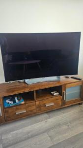 a wooden entertainment center with a large flat screen tv at Jämsän Kulma in Halli