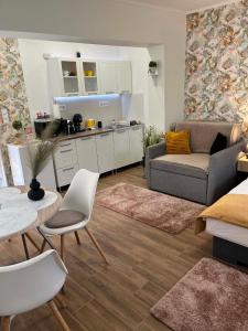 a kitchen and living room with a couch and a table at Várfal apartman I in Eger