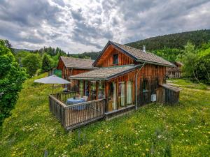 a wooden house with an umbrella in a field at Chalet SCHNEEHASE 10min - Kreischberg in Stadl an der Mur