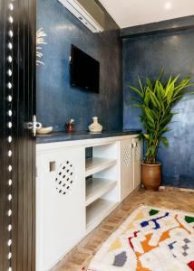a living room with a tv on a wall at The Yogi Surfer in Taghazout